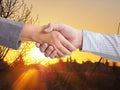 Hand shake in front of morning sun rise, business dual with new goal and success concept
