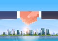Hand shake icon business handshake partnership agreement concept successful cooperation over big modern city skyscraper Royalty Free Stock Photo