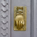 Hand shaped bronze knocker