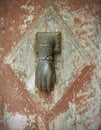 Hand shaped door knocker on weathered rustic door