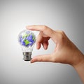 Hand showing crumpled world paper symbol in light bulb