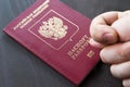 Hand showing the fig sign, on red passport background