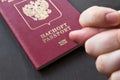 Hand showing the fig sign, on red russain passport background