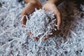 Hand showing heap of shredded paper.