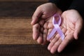 Hand showing lavender ribbon on wooden table