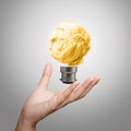 Hand showing light bulb crumpled paper Royalty Free Stock Photo