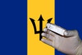 A hand showing a negative antigenic corona rapid test in front of a Flag of Barbados