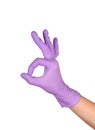 Hand showing ok sign against white background. Hand in a purple latex glove isolated on white. Woman`s hand gesture or sign