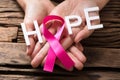 Hand Showing Pink Ribbon With Hope Text