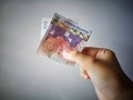 Hand showing 100 Ringgit Malaysia & x28;MYR& x29; money with vintage background and selective focus. Royalty Free Stock Photo