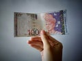 Hand showing 100 Ringgit Malaysia & x28;MYR& x29; money with vintage background and selective focus. Royalty Free Stock Photo