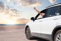 Hand showing thumb up out window car on blue sky, white clouds, sun and sea background Royalty Free Stock Photo