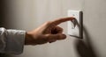 A hand is shown pressing a light switch labeled \