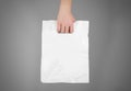 Hand shows blank plastic bag mock up isolated. Empty white polyethylene package mockup. Consumer pack ready for logo design or id Royalty Free Stock Photo