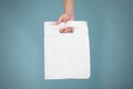 Hand shows blank plastic bag mock up isolated. Empty white polyethylene package mockup. Consumer pack ready for logo design or id Royalty Free Stock Photo