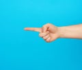 Hand shows forefinger gesture on a blue background