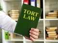 Hand shows a Tort law book in the office.