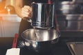 Hand sifting flour powder from sieve on black kitchen table