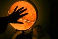 Hand silhouette in front of an illuminated earth globe