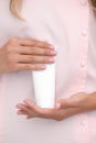 Hand skin care. Female hands holding one white cream tube against body in pink cloth, beautiful beautician woman hands with Royalty Free Stock Photo