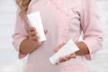 Hand skin care. Female hands holding two white cream tubes against body in pink cloth, beautiful beautician woman hands with Royalty Free Stock Photo