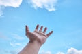 Hand with blue sky and cloud in background. Royalty Free Stock Photo