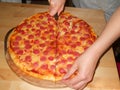 Hand slicing the pizza