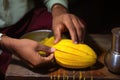 hand slicing a ripe mango to make lassi