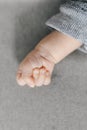Handle of small newborn baby clenched into fist on gray background with copy space Royalty Free Stock Photo