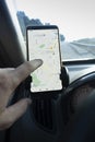 Hand with a smartphone in the car. Looking at phone Google Maps