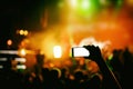 Hand with a smartphone records live music festival, live concert, show on stage Royalty Free Stock Photo