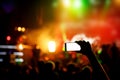 Hand with a smartphone records live music festival, live concert, show on stage Royalty Free Stock Photo