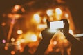 Hand with a smartphone records live music festival and taking photo Royalty Free Stock Photo