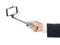 Hand and smartphone with selfie stick Royalty Free Stock Photo