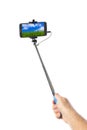 Hand with smartphone selfie stick and landscape my photo