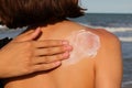 Hand smearing sun protection cream in girl's back Royalty Free Stock Photo