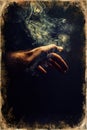 Hand in smoke on black background. Old photo effect. Royalty Free Stock Photo