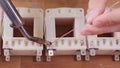 Hand soldering the terminals of a transformer coil - close up