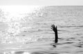 hand of man drowning in the ocean with black and white effect