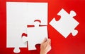 Hand solving a puzzle piece on red background Royalty Free Stock Photo