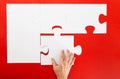 Hand solving a puzzle piece on red background Royalty Free Stock Photo