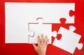 Hand solving a puzzle piece on red background Royalty Free Stock Photo