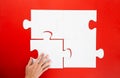 Hand solving a puzzle piece on red background Royalty Free Stock Photo