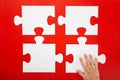 Hand solving a puzzle piece on red background Royalty Free Stock Photo