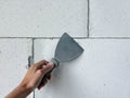 A hand with a spatula on a white block wall. Preparing for interior wall finishing. Renovation and construction. Royalty Free Stock Photo