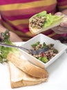 Hand with spicy minced pork with bread on wooden table, Thai foo