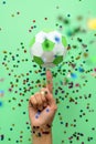 Hand spinning paper soccer ball on green background. Origami. Paper craft. Soccer game concept Royalty Free Stock Photo