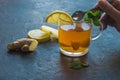 A hand with a spoon,a cup with ginger tea and lemon Royalty Free Stock Photo
