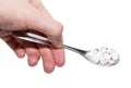 Hand and spoon full of pills Royalty Free Stock Photo