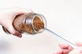 Hand spooning up instant coffee from glass jar Royalty Free Stock Photo